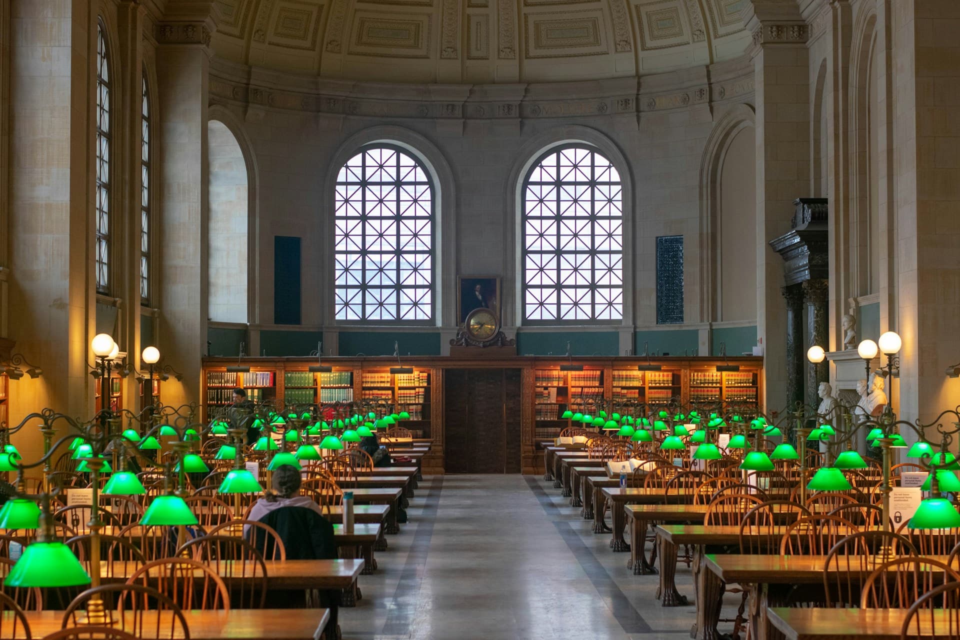 Grand library reading room with green lamps